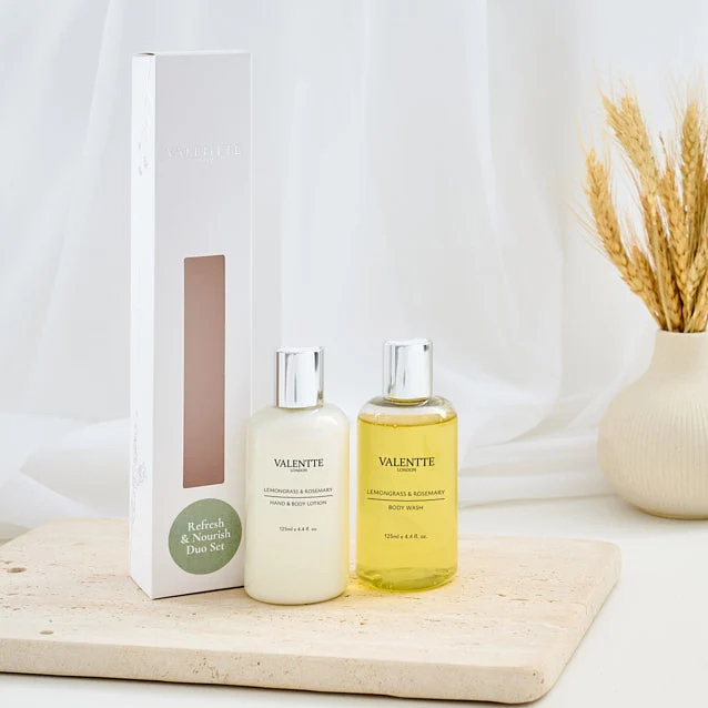 Body Wash Two bottles of hair care products beside a box, with a neutral background and decorative vase.